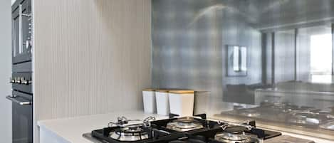 Una cocina moderna con estufa a gas, horno y un amplio ventanal.