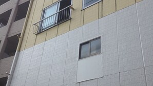 A multi-story building with a beige and white facade, featuring balconies and windows. - Edo Tokyo Hostel (Tokyo)
