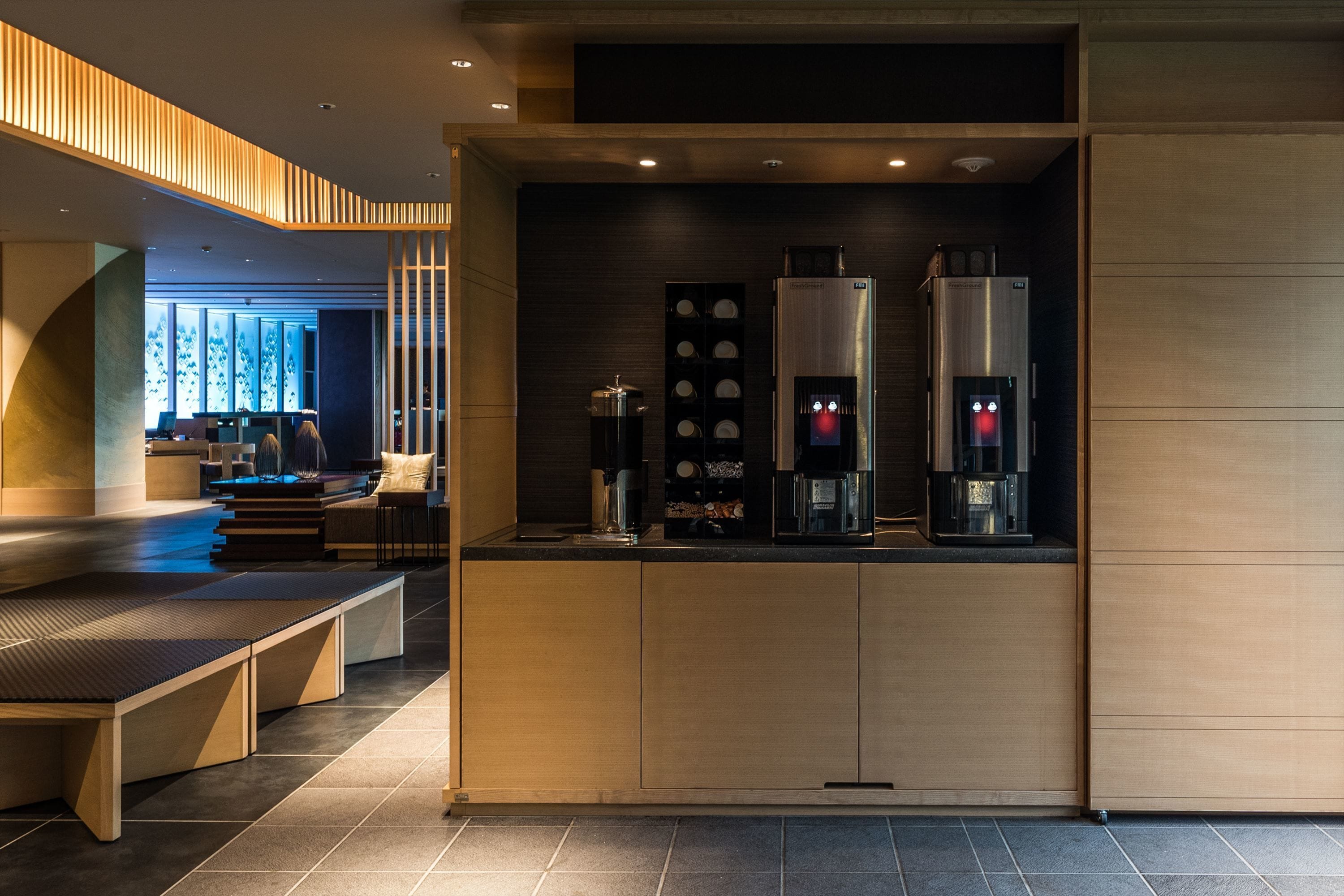 Una cocina moderna con electrodomésticos integrados, una zona de estar y vista al salón.