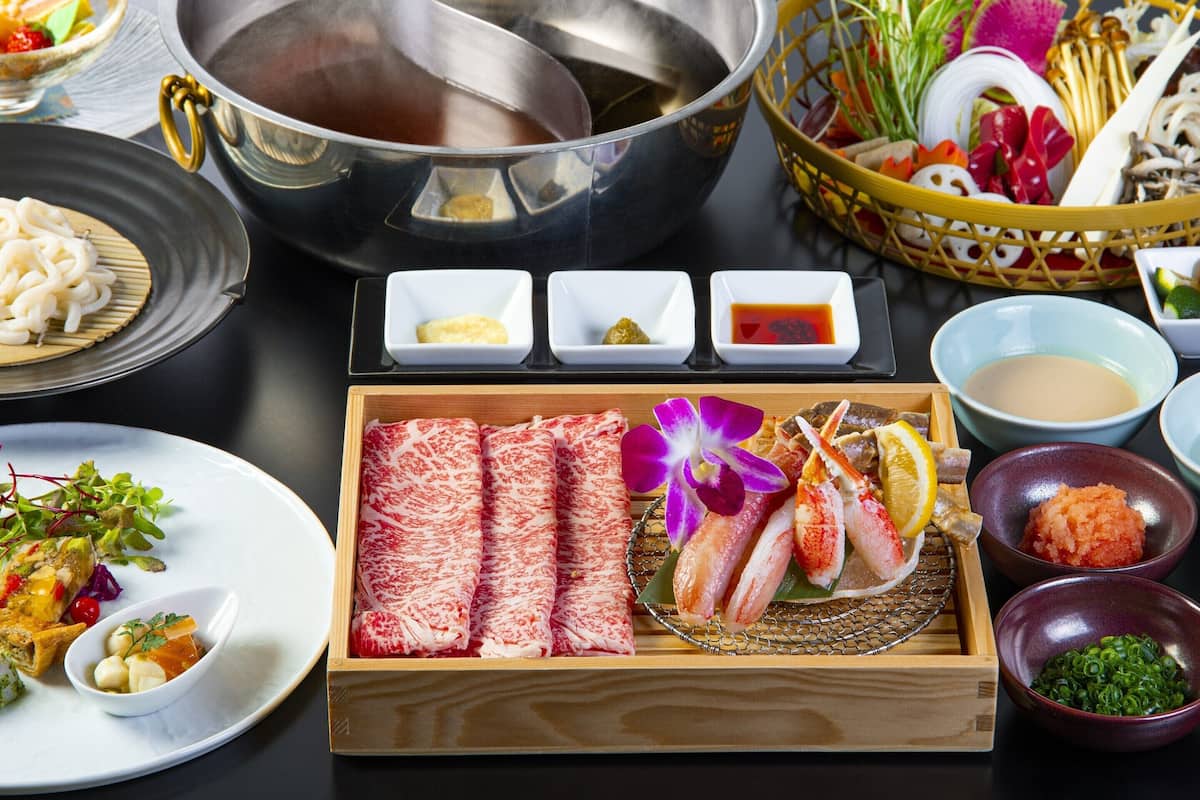 Diverse Japanse gerechten, waaronder sushi, sashimi en een heetpot.