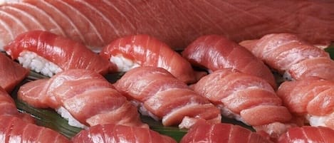 Variedad de sushi, incluyendo nigiri y sashimi, dispuesto sobre una tabla de madera.