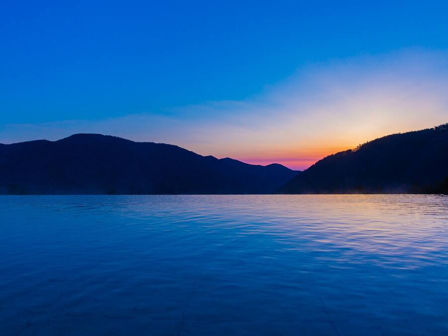 A serene lakeside view with mountains in the background.