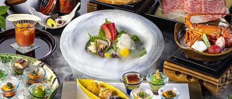 A variety of dishes and drinks, including seafood and sushi, arranged on a table.