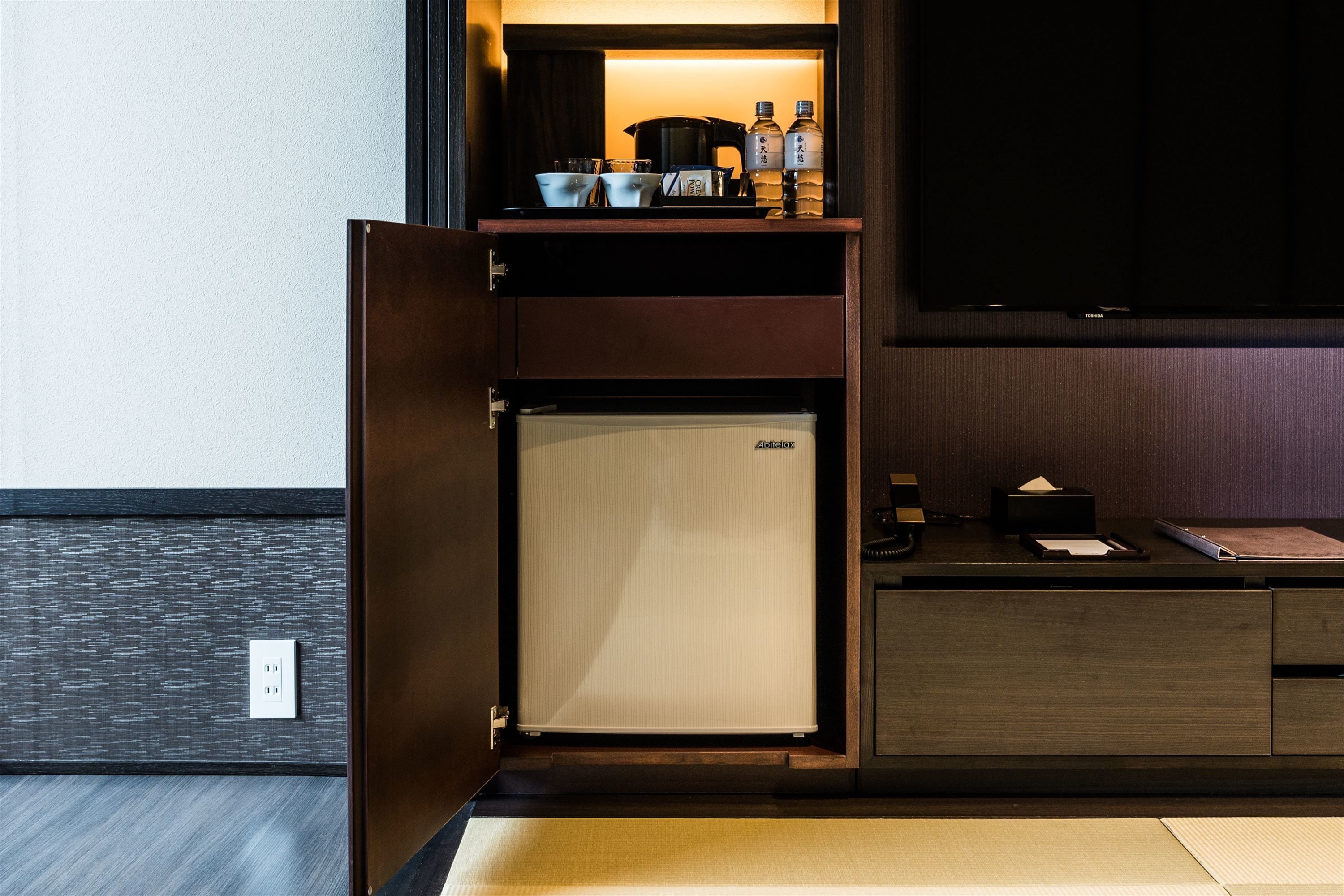 A compact kitchenette with a refrigerator, a microwave, and a coffee maker.