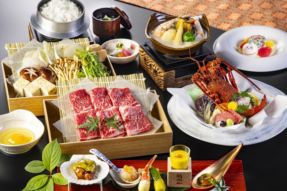 Diverse Japanse gerechten, waaronder sushi, sashimi en een kreeft op een schaal.