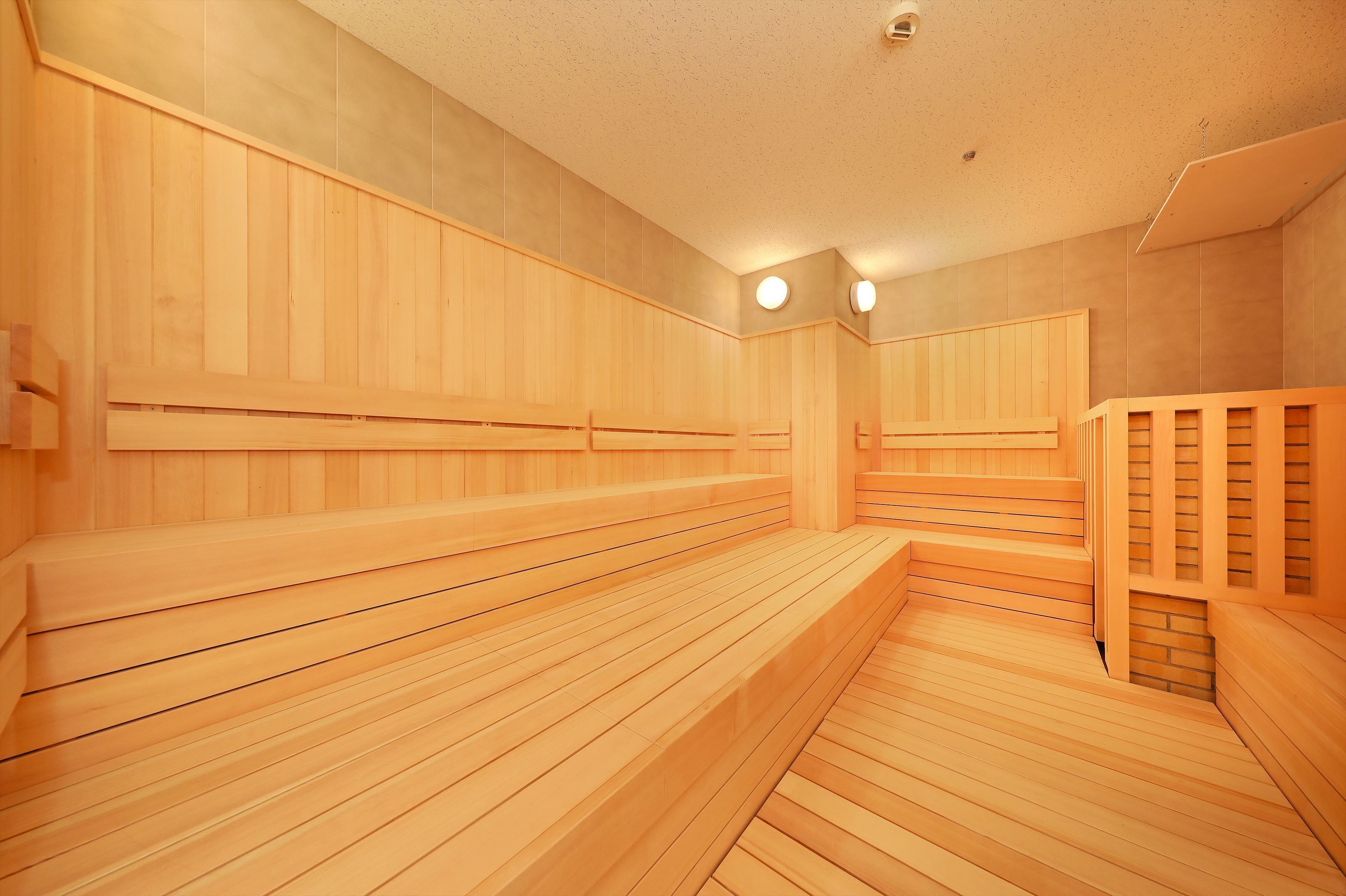 A wooden sauna with benches and a staircase.