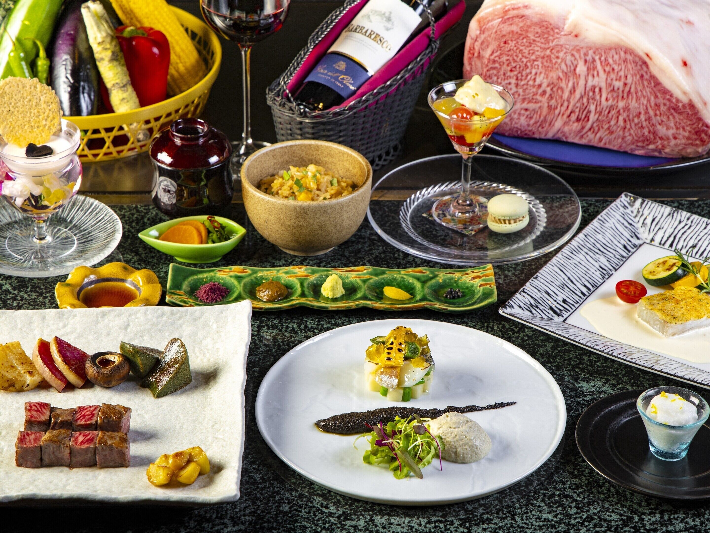 A variety of dishes and food items on a table, including a bowl of rice, a plate with a fish dish, and several other plates with different foods.