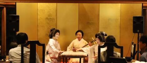 A traditional Japanese room with tatami flooring, a low table, and a red cushion.
