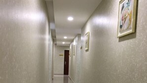 Um corredor com piso e paredes revestidas, levando a uma porta no final.