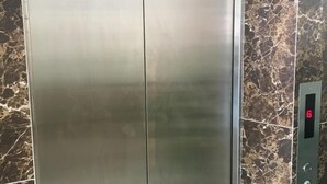 A metallic elevator with a marble wall. - SOHO HOTEL (SEMENYIH) SDN. BHD. (Semenyih)