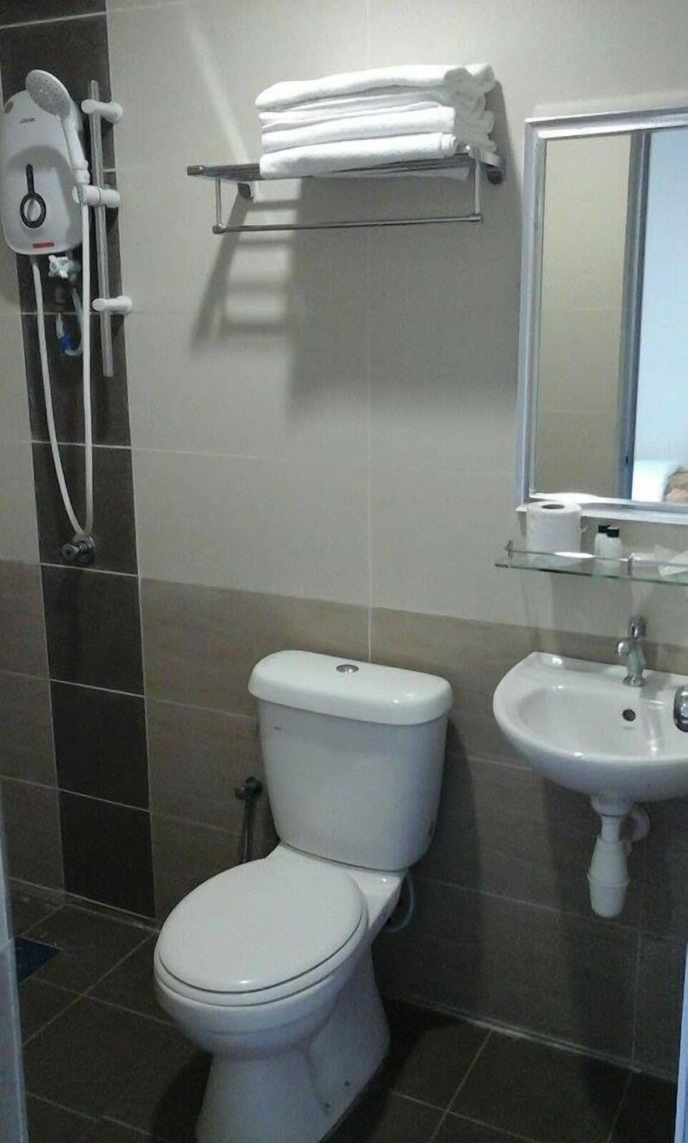 A bathroom with a toilet, a sink, and a towel rack.