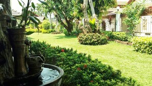A well-maintained garden with a water feature, neatly trimmed hedges, and a variety of plants. - Baan Laksee Pool Villa (Pattaya)