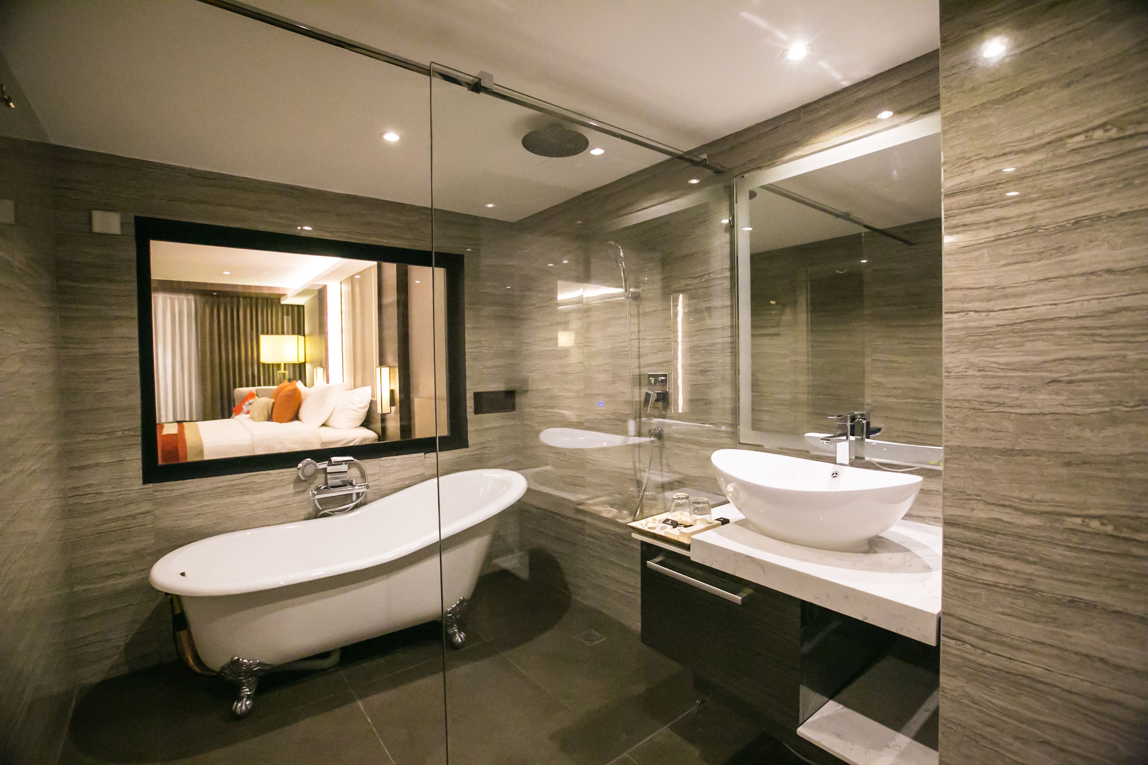 A modern bathroom with a freestanding bathtub, a double sink vanity, and a large mirror.