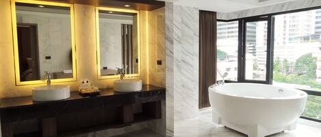 Ein modernes Badezimmer mit einem großen Spiegel, zwei Waschbecken, einer Badewanne und Blick auf die Stadt.