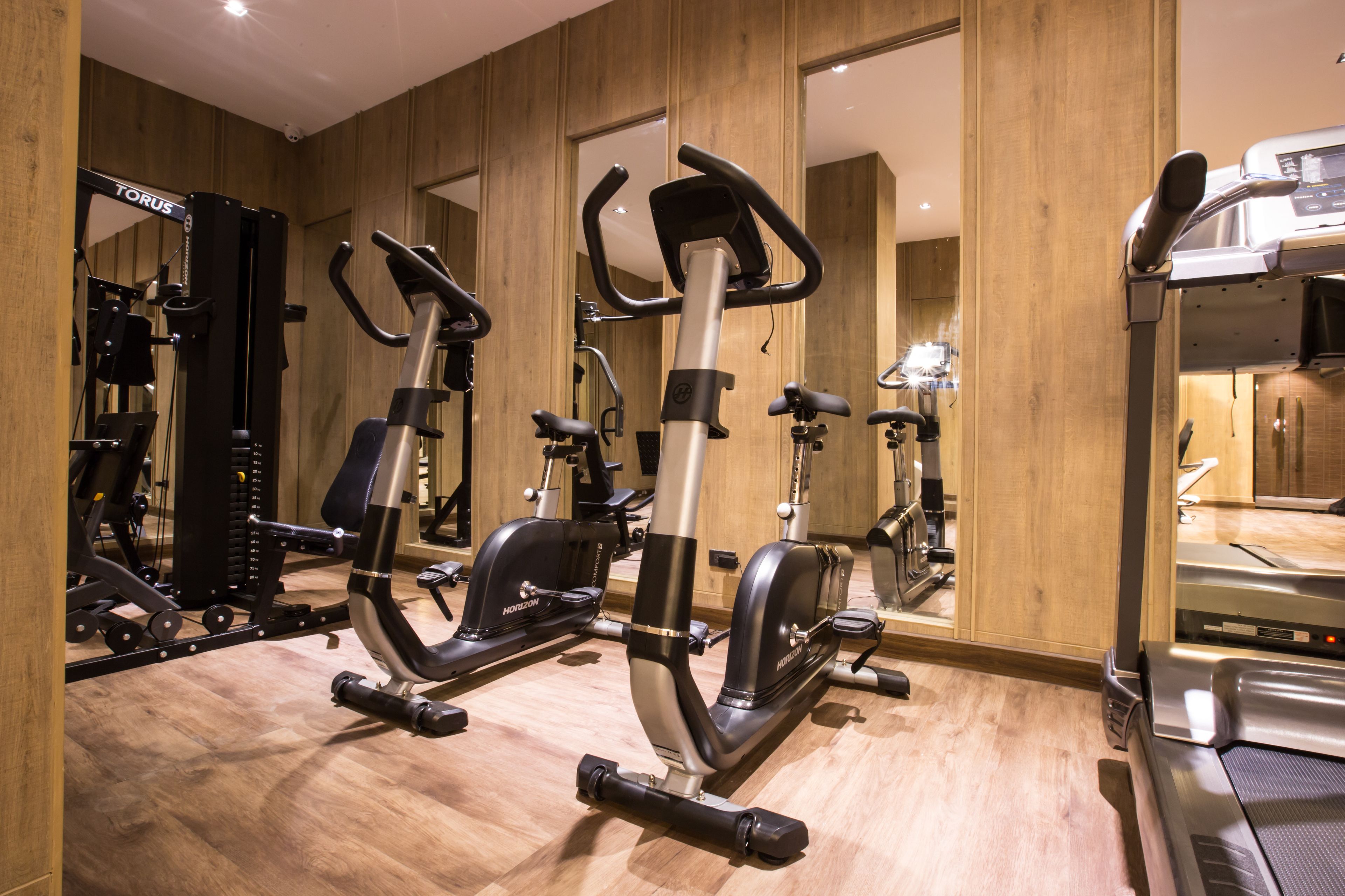 A gym with various exercise equipment, including ellipticals and a treadmill.