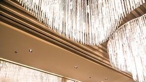 Eine moderne Lobby mit hoher Decke, einer großzügigen Sofagarnitur und einem glänzenden Marmorboden.