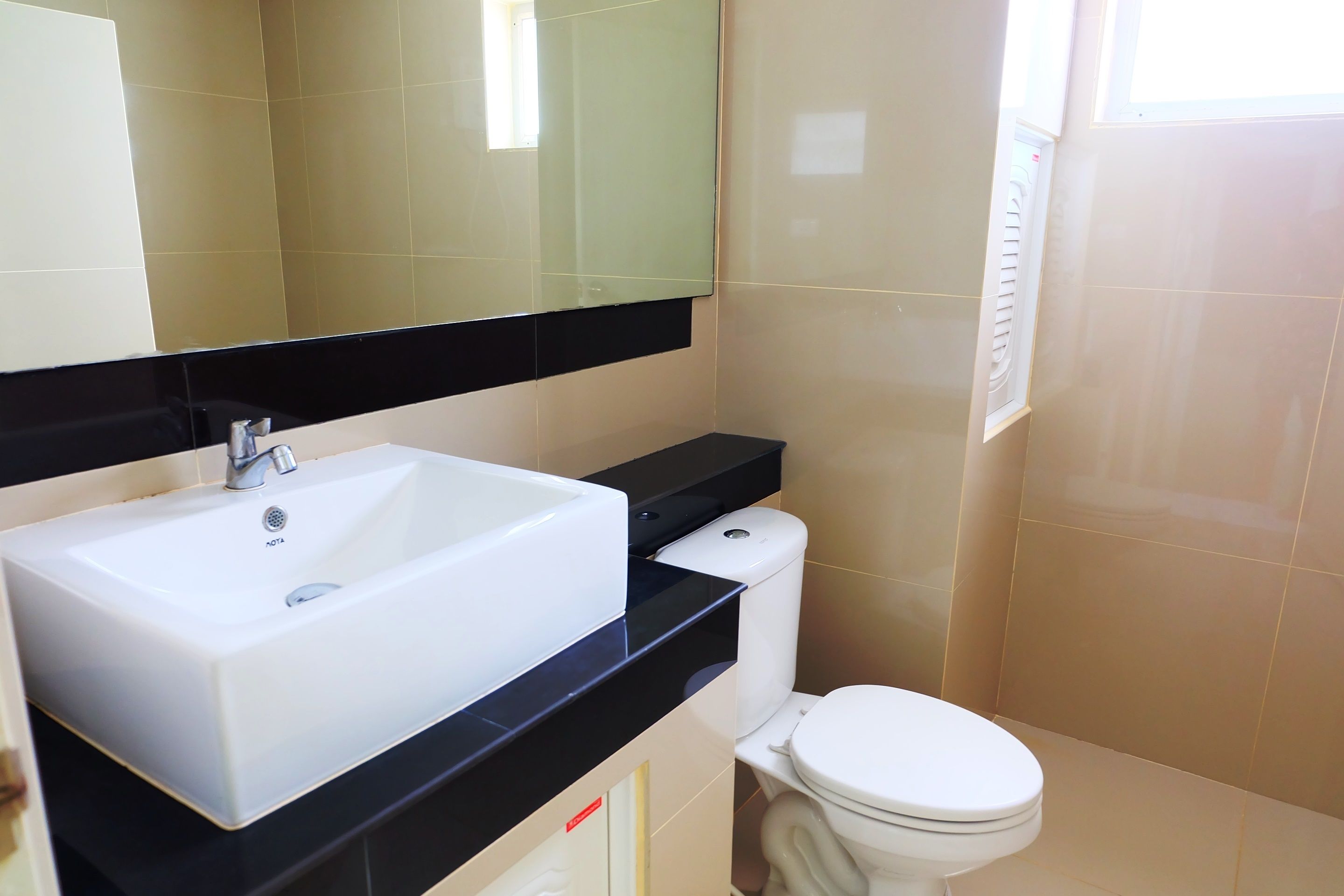 A bathroom with a white sink, black countertop, and a toilet.