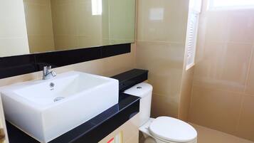 A bathroom with a white sink, black countertop, and a toilet.