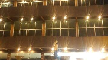A building with a prominent 'Chai' sign at the top, multiple floors with evenly spaced windows, and a person standing on the lower level.