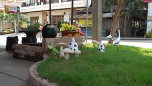 A landscaped area with a fountain, decorative mushrooms, and a bird sculpture. - Souvanna Hotel 2 (Vientiane)