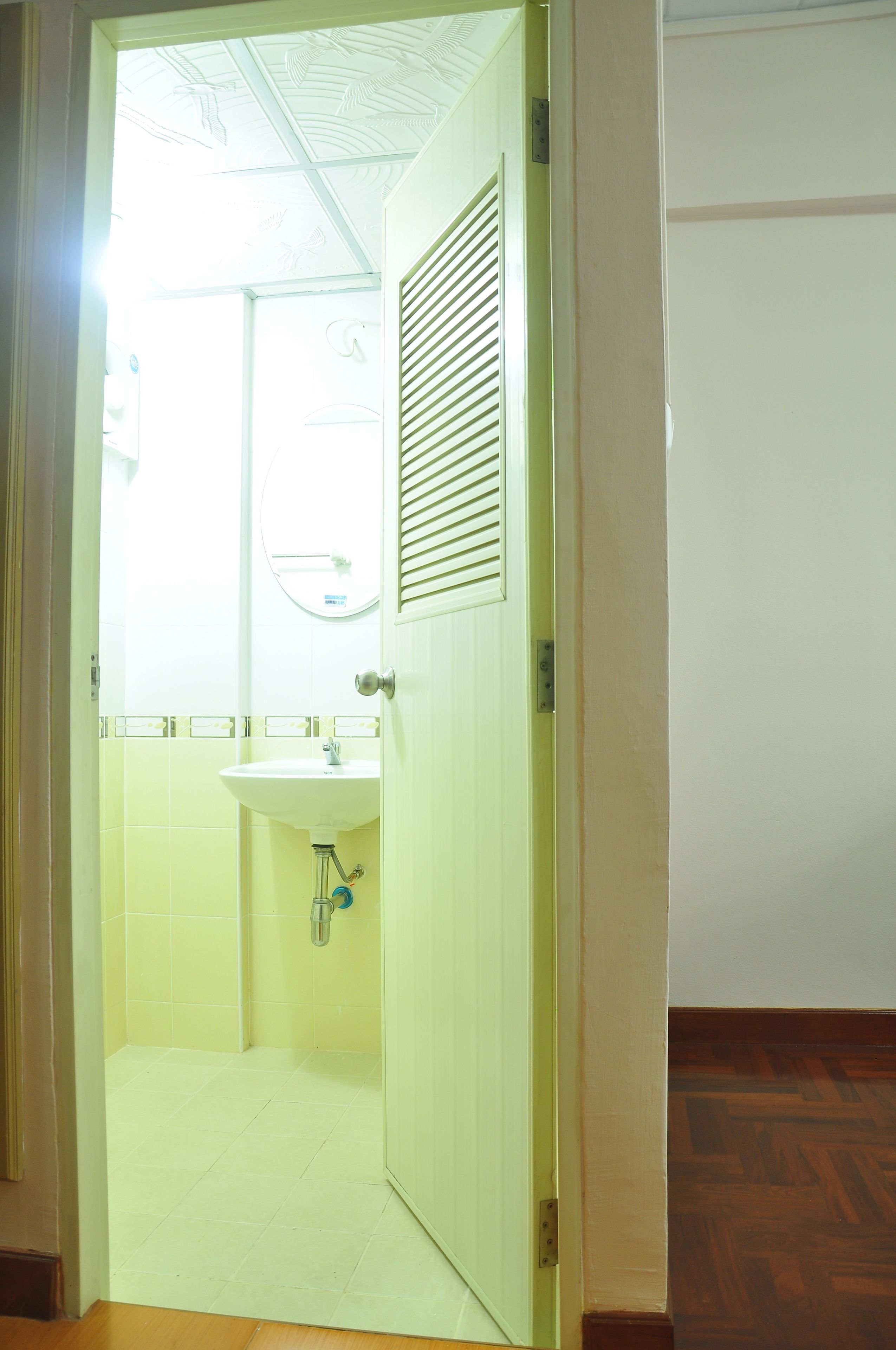 A bathroom with a toilet, sink, and a mirror.