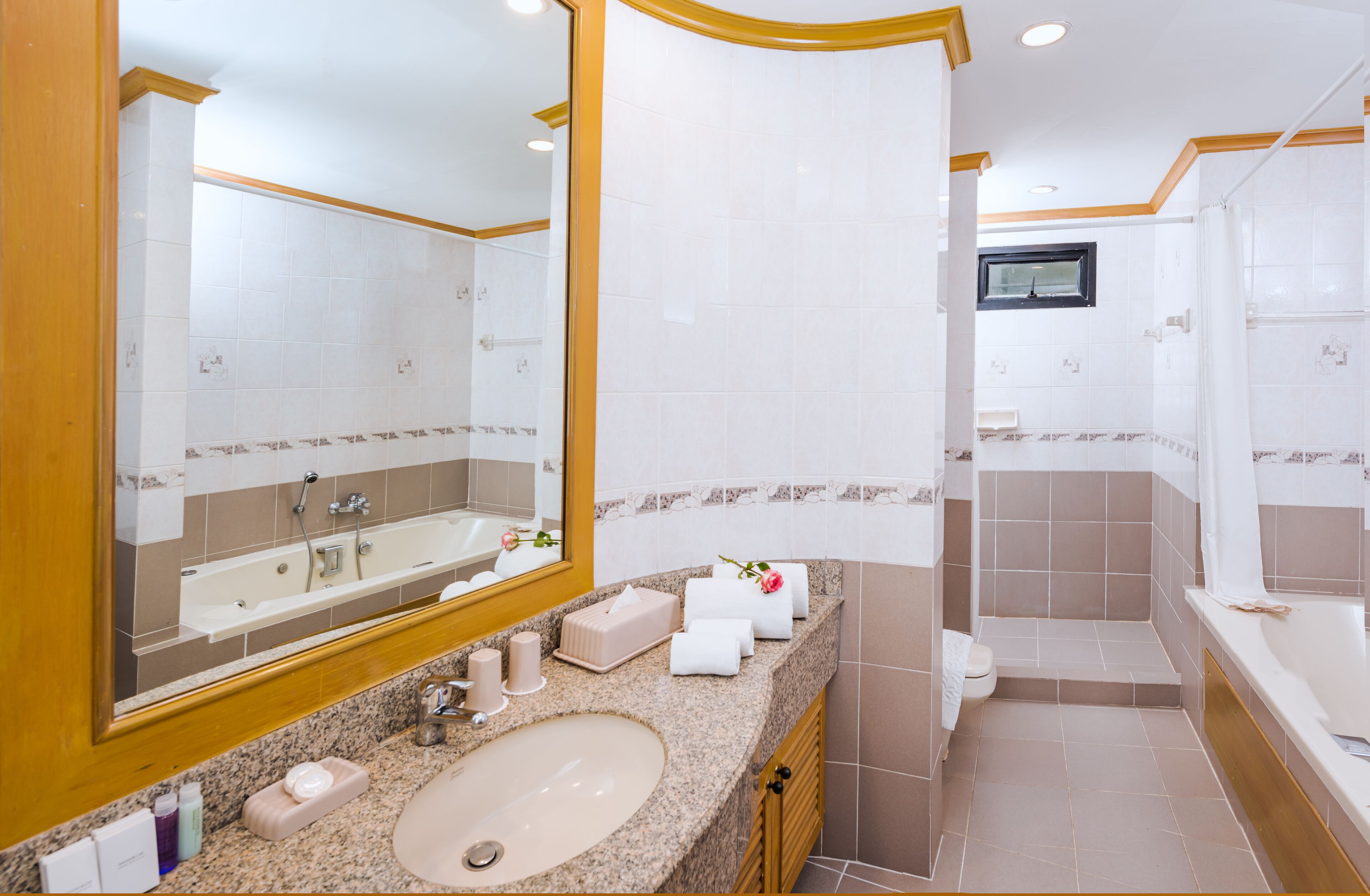 Un baño moderno con un lavamanos grande, espejo y bañera.