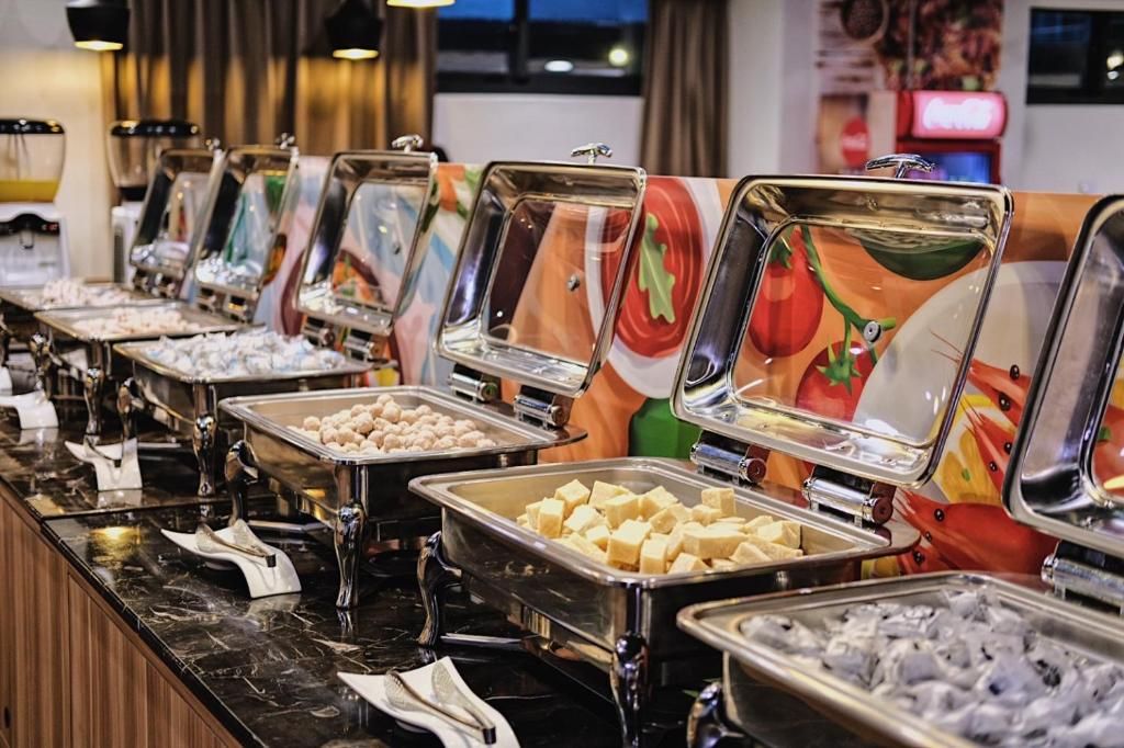 A buffet with various food items and a Coca-Cola sign in the background.