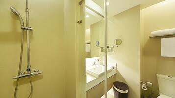 A modern bathroom with a glass shower enclosure, a sink, and a toilet.