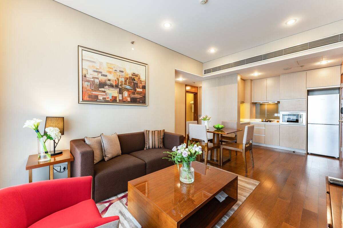 Un salon moderne comprenant un canapé, une table basse et un coin repas avec des chaises et une table.