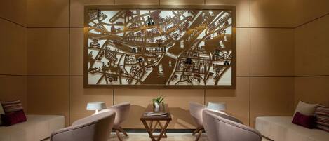 A modern lobby with a large cityscape artwork, two sofas, and a coffee table.
