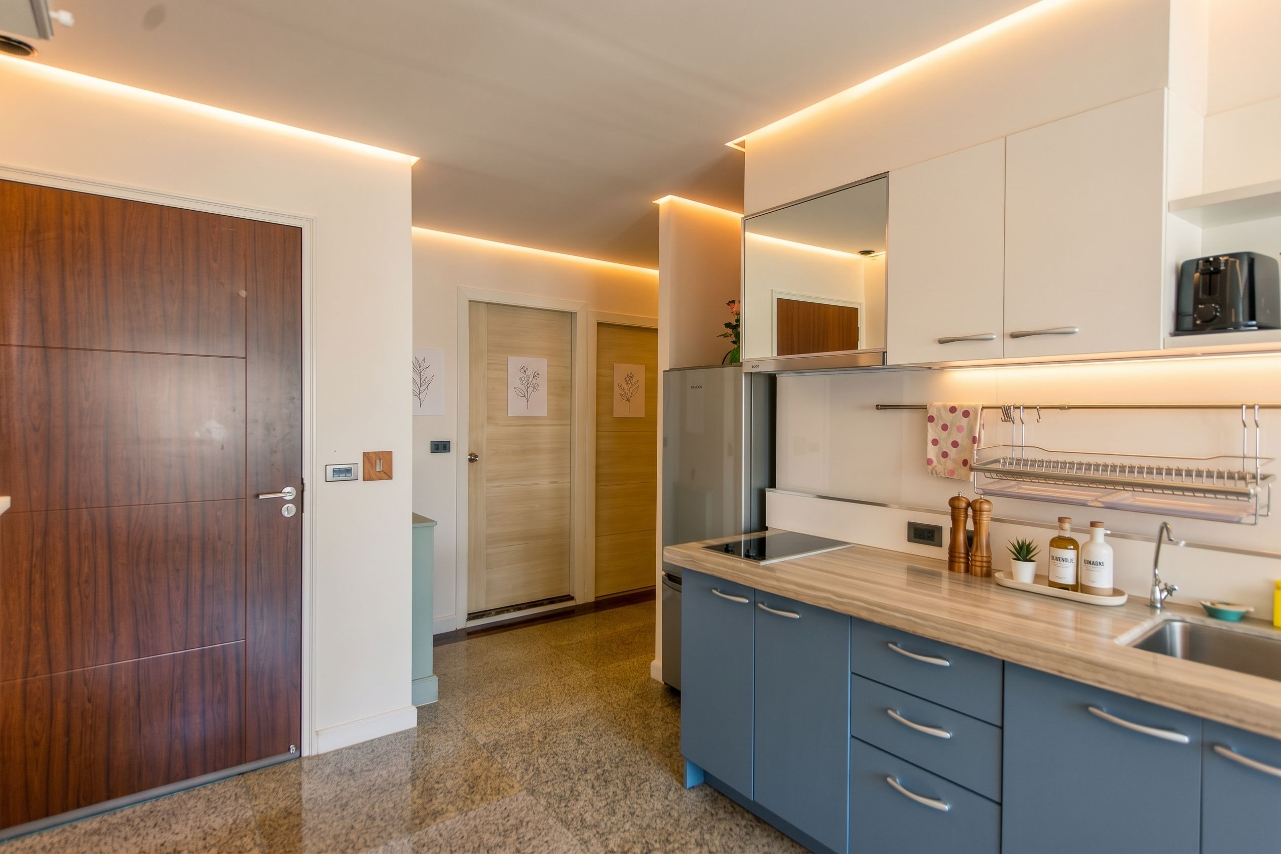 Una cocina moderna con horno empotrado, cafetera y pileta de acero inoxidable.