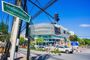 A modern building with a distinctive geometric facade, a traffic light, and a street sign. - Viengping Mansion (Chiang Mai)