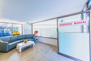 A waiting room with a sofa, a coffee table, and a sign indicating it's a waiting area. - Viengping Mansion (Chiang Mai)