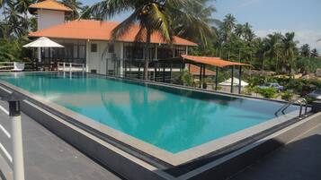 Een buitenzwembad, parasols voor strand/zwembad