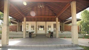 A covered outdoor area with stone columns and steps leading to a building entrance. - Sungreen Resort (Habarana)