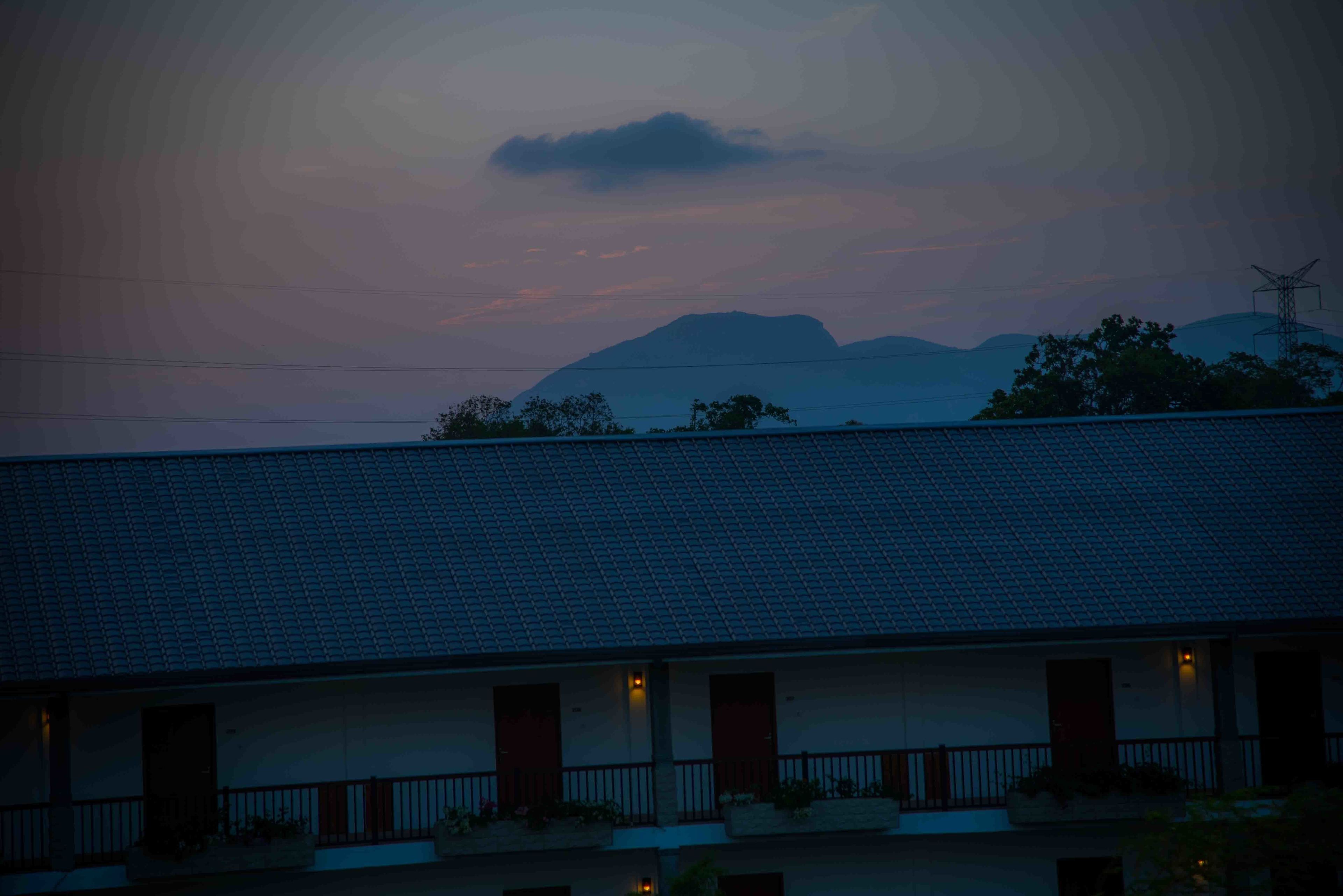 A building with a tiled roof and multiple windows, likely a hotel or motel.