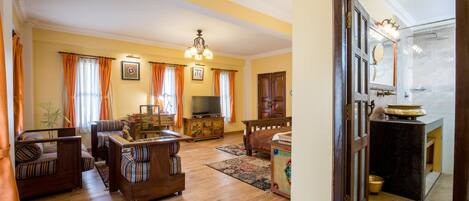 Amplia sala de estar con televisor, sofá y muebles de madera.