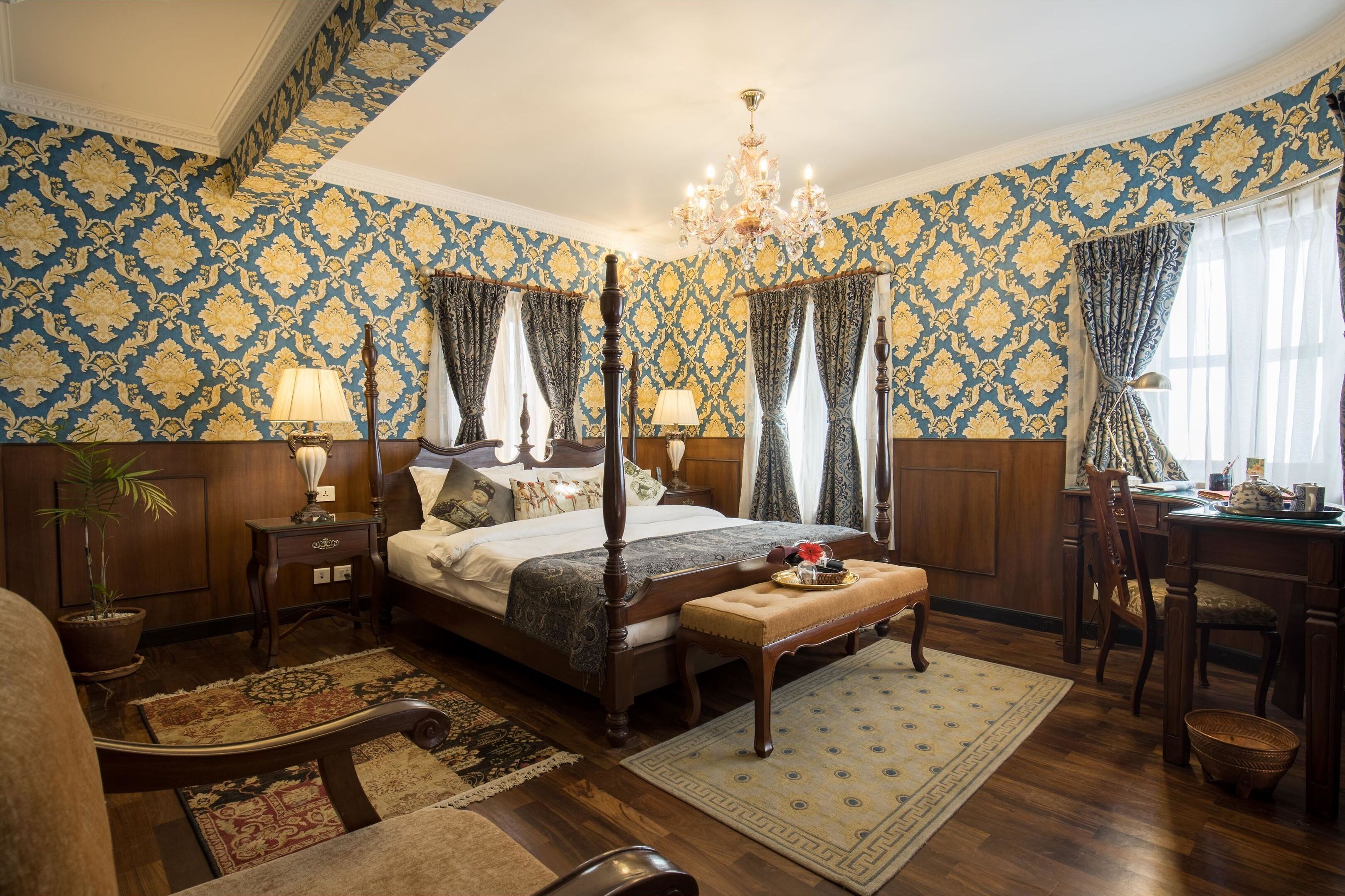 Un dormitorio con cama con dosel, muebles de madera y papel tapiz estampado.