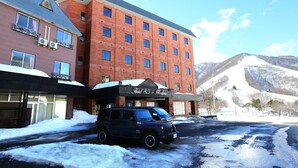 A hotel with a brick facade, multiple windows, and a sign reading "Hotel Silk in Madonna." - Hotel Silk in Madarao (Iiyama)
