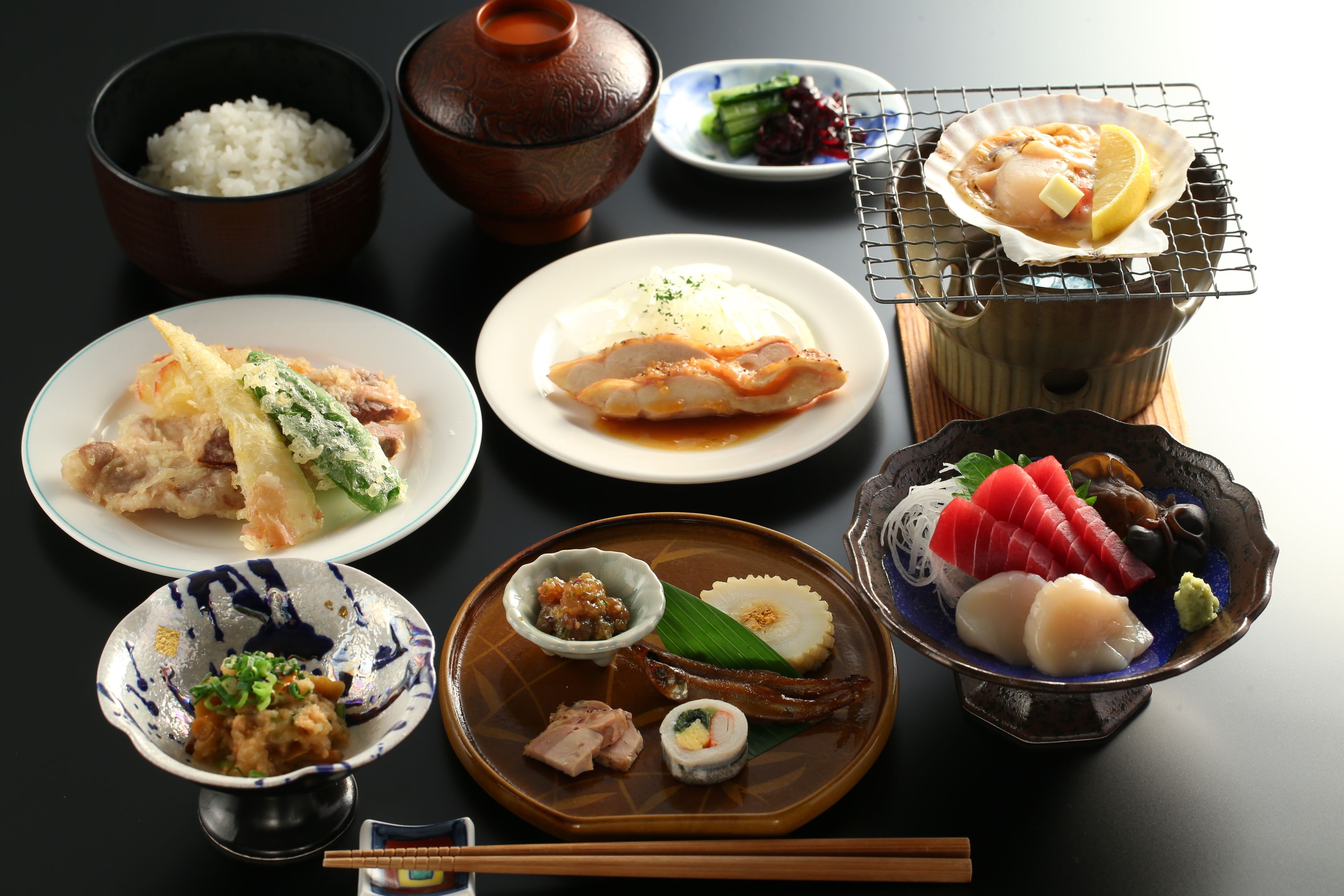 Una variedad de platos japoneses, como sushi, sashimi y cuencos de arroz.