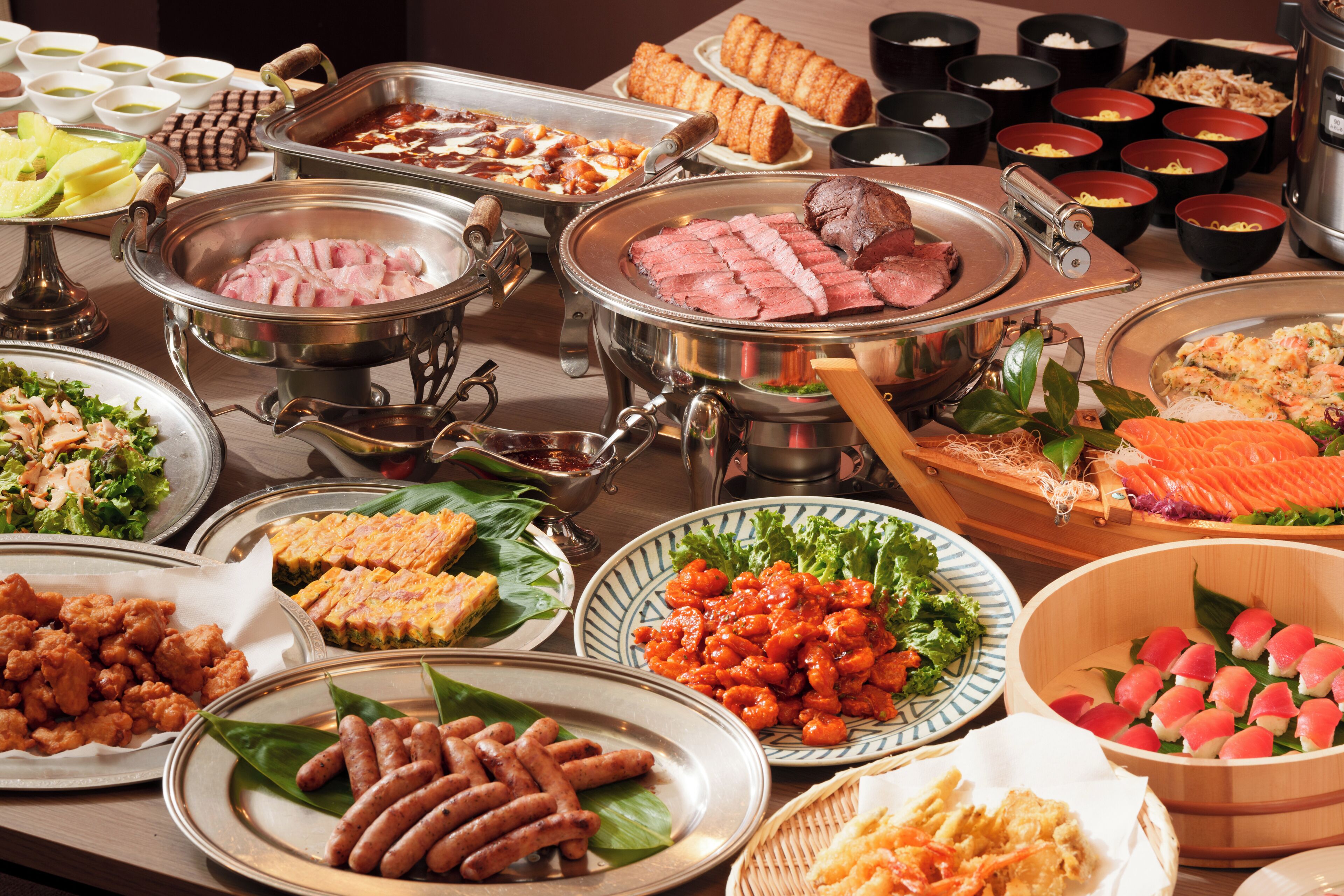 A buffet with various dishes including meats, seafood, and salads.