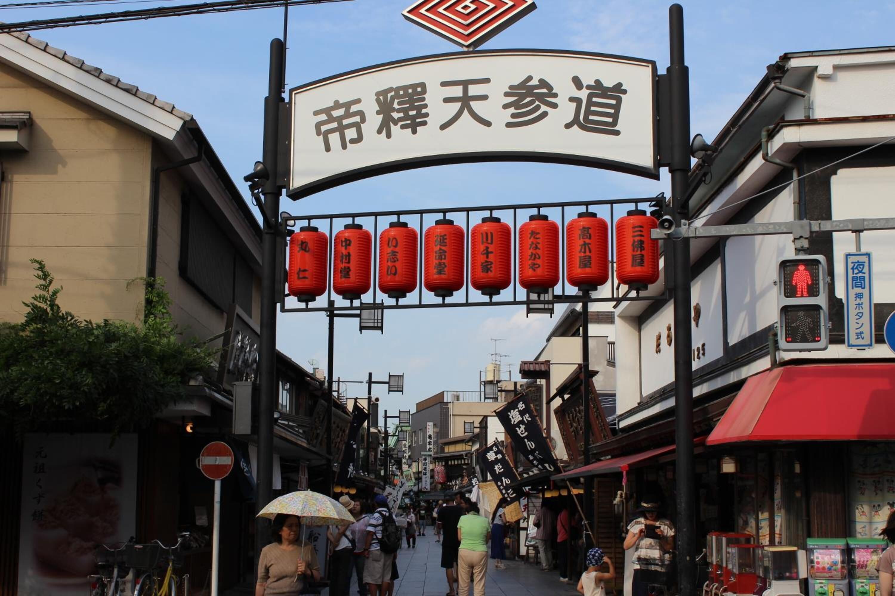 A street with a sign reading "Festival Day Path" and red lanterns hanging above.
