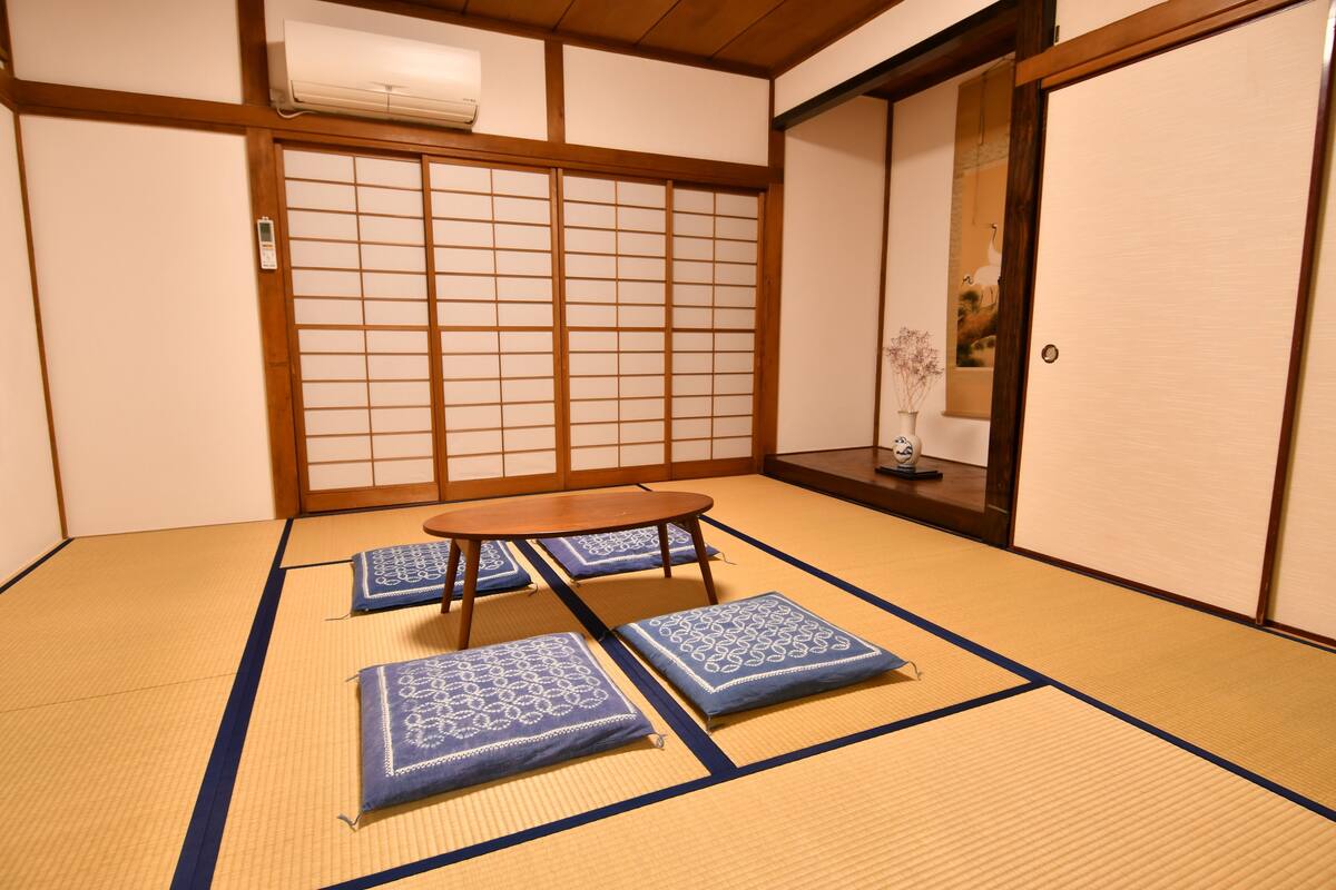 A tatami mat room with a low wooden table and cushions.