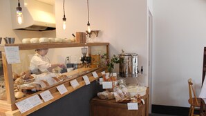 A bakery display with various baked goods and price tags. - Hostel HANA AN (Tokyo)