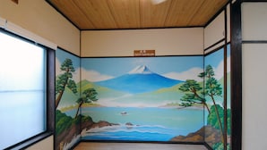 A room with a mural of a mountain and trees, wooden flooring, and a sign indicating the room's name. - Hostel HANA AN (Tokyo)