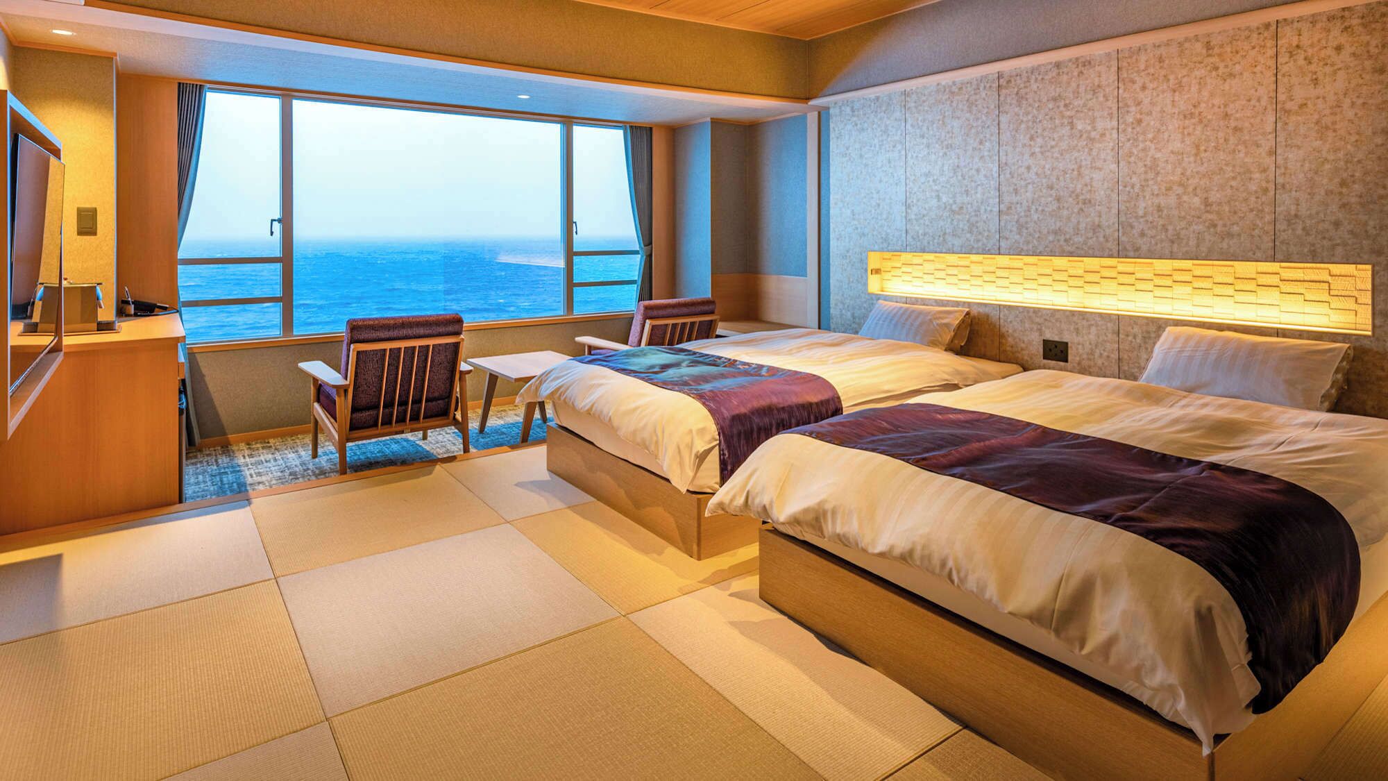 Una habitación de hotel con un ventanal grande, una cama, un escritorio y una silla.