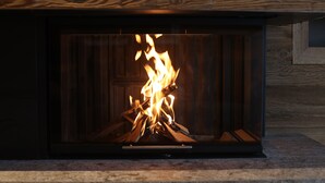 A fireplace with a visible fire burning inside. - Severins The Alpine Retreat (Lech am Arlberg)