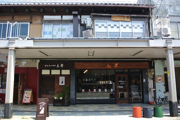 Un edificio japonés tradicional con escaparate, vigas de madera y una bicicleta estacionada afuera.