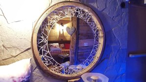 A circular mirror with a geometric design on a stone wall. - Logis Hôtel et Spa Le Christiania (La Salle-les-Alpes)