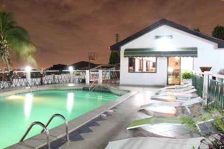 Outdoor pool, pool loungers. Hill View Hotel McCarthy Hills